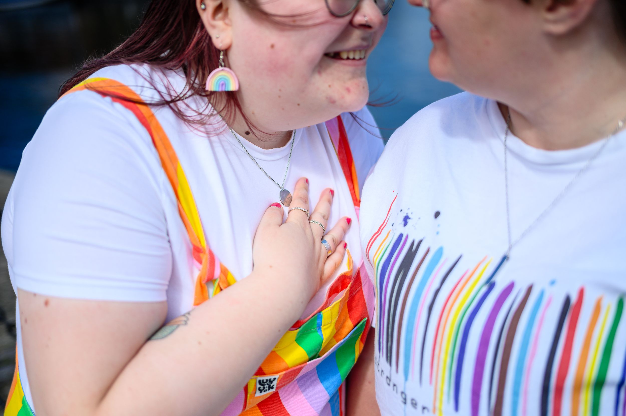 Two women wearing pride coloured clothing